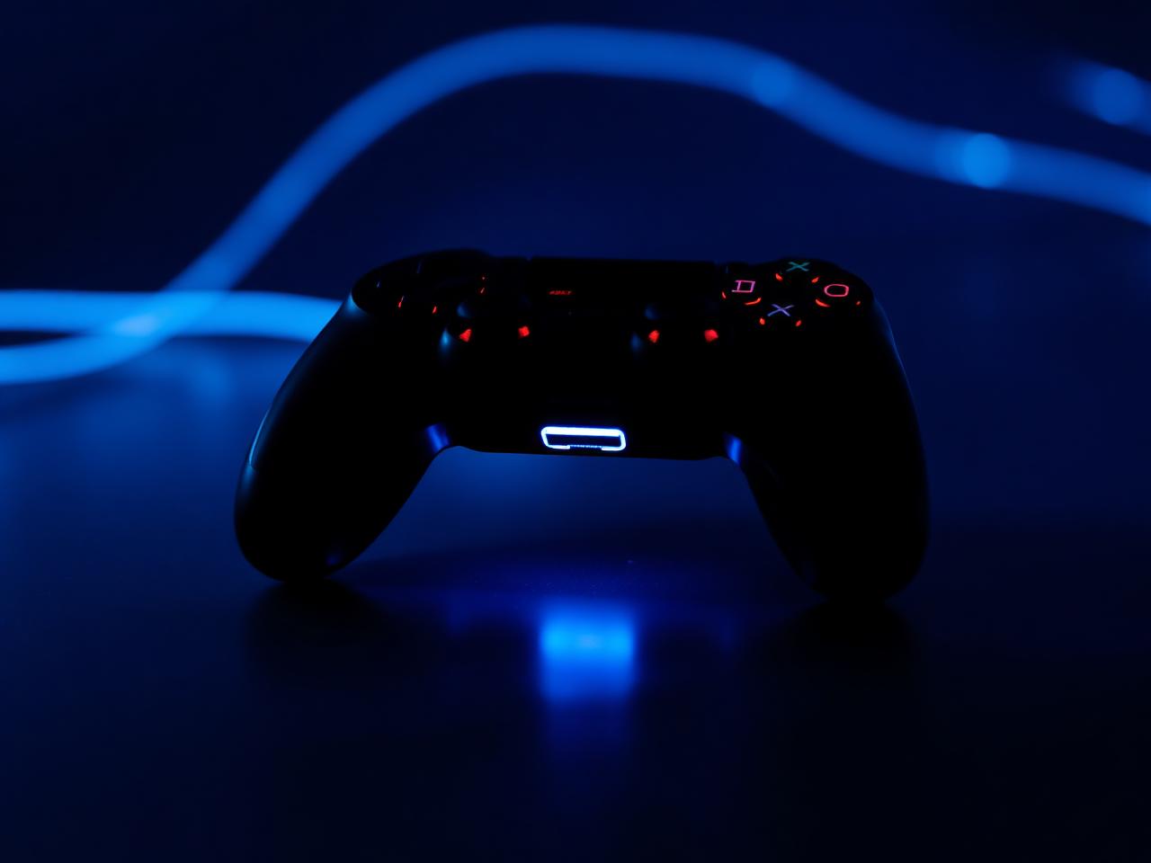 Glowing controller on dark surface with electric blue rim light
